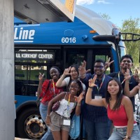 Group of students posing near Bus stop with Anchor up